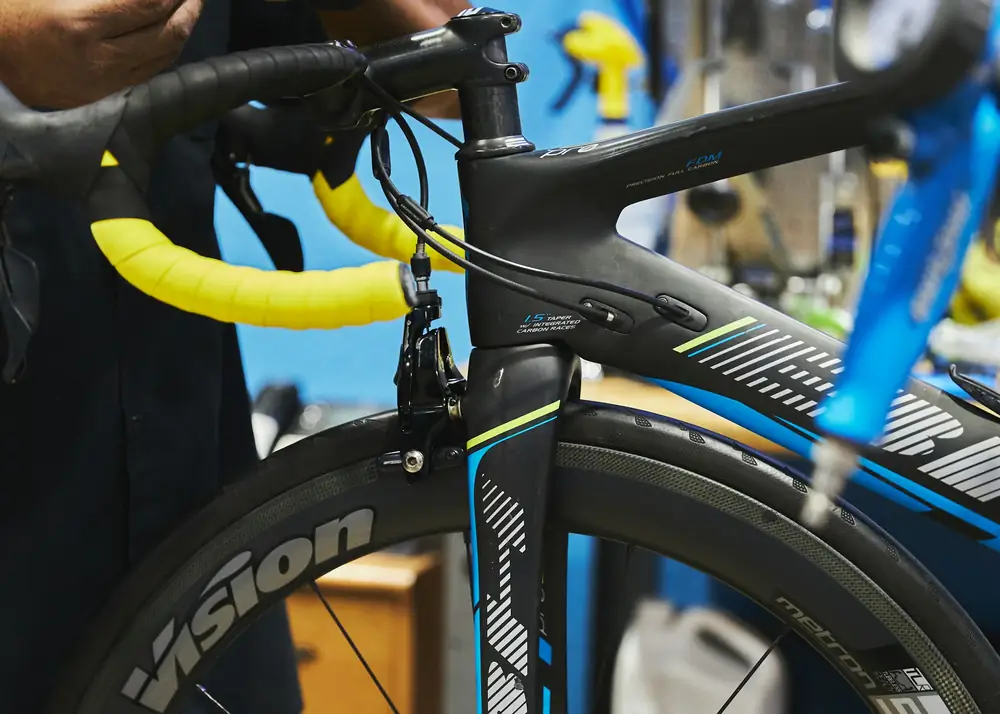 A mechanic adjusting a bike in the stand